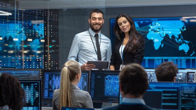 Project Manager Introduces New Head of the Department. Team of Engineers and Programmers are Building Machine Learning System. Displays Show Working Model of Neural Network.  - Powered by Adobe