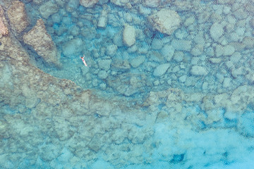 An aerial view of the beautiful Mediterranean sea, where you can se the rocky textured underwater corals and the clean turquoise water of blue lagoon Agia Napa