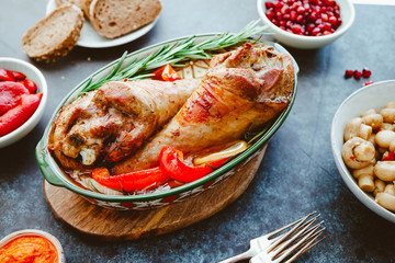 Festive dish for Thanksgiving, roasted turkey legs with vegetables on a table with snacks.