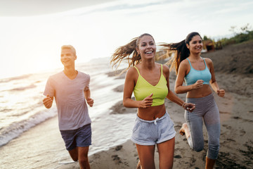 Group of sport people jogging on the beach