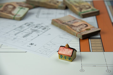 House and house plan with blurred Thai money background, house buying concept.