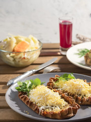 Karelian Pirakka pies located on a gray plate. Nearby is a fermented beetroot juice and a cup with sauerkraut. Traditional dish of Karelia and Finland from rye flour with different fillings. Close-up