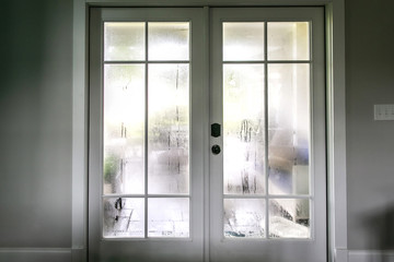 The humidity of the outdoor temperature on a summer day in South Georgia. The air conditioning is on inside and the cold air inside makes the back glass pane doors condensate and become foggy. - obrazy, fototapety, plakaty