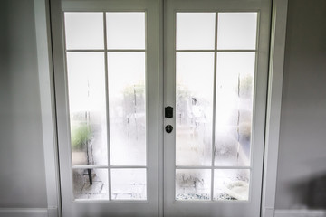 The humidity of the outdoor temperature on a summer day in South Georgia. The air conditioning is on inside and the cold air inside makes the back glass pane doors condensate and become foggy.