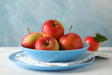 Composition with plate and apples on white wooden background, copy space