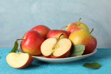 Apples and plate on blue background, space for text