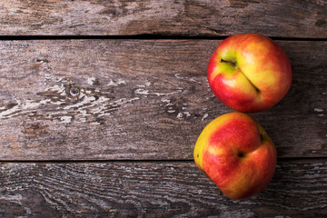 Trendy ugly food concept. Two green apples on a dark brown wooden background. Copy space. Fruit with a strange shape.