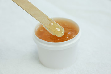 Liquid yellow paste for shugaring on white background. Depilation and body care