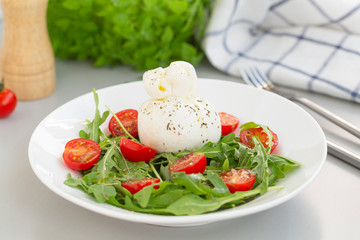 Fresh Salad with Italian burrata cheese, arugula, cherry tomatoes and olive oil. Healthy eating. Selective focus 