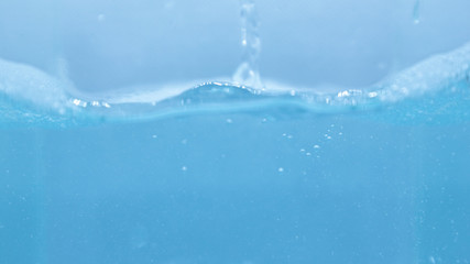 Water and soap, soap bubbles on the water surface, water waves, blue water