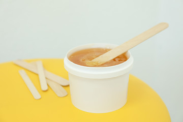 Liquid yellow paste for shugaring on yellow background, space for text