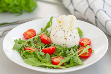 Fresh Salad with Italian burrata cheese, arugula, cherry tomatoes and olive oil. Healthy eating. Selective focus 