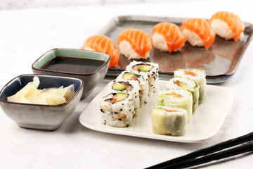 close up of sashimi sushi set with chopsticks and soy - sushi roll with salmon and sushi roll with smoked eel