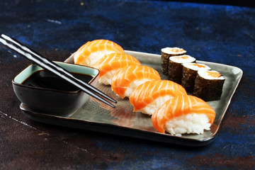 close up of sashimi sushi set with chopsticks and soy - sushi roll with salmon and sushi roll with smoked eel