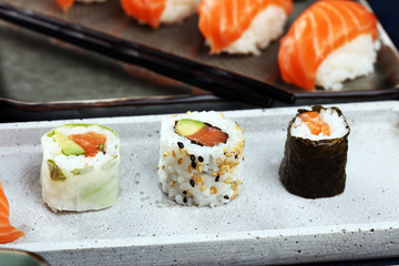 close up of sashimi sushi set with chopsticks and soy - sushi roll with salmon and sushi roll with smoked eel