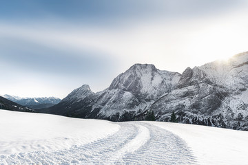 Fototapeta premium Alpine winter landscape with snowy mountains and snowy road