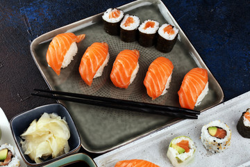 close up of sashimi sushi set with chopsticks and soy - sushi roll with salmon and sushi roll with smoked eel