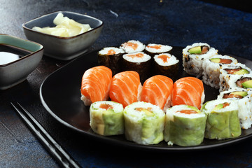 close up of sashimi sushi set with chopsticks and soy - sushi roll with salmon and sushi roll with smoked eel