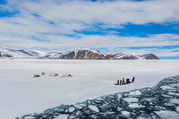 Aerial drone photo of tourists visit the floe edge near Sirmilik National Park in Nunavut, Canadaa