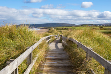 Wood boardwalk at Inverness Beach on Cape Breton Island, Nova Scotia, Canada on autumn day.