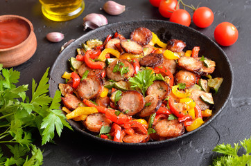 Slices of fried sausages with vegetables