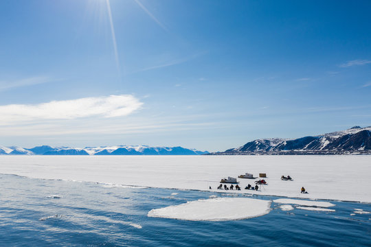 Aerial drone photo of tourists visit the floe edge near Sirmilik National Park in Nunavut, Canadaa