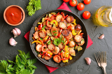 Slices of fried vegetables with sausages and spices