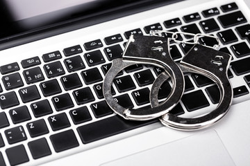 Handcuffs on laptop keyboard