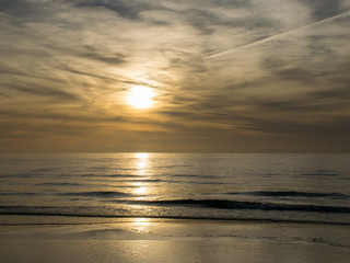 landscape with defocused beautiful dramatic golden sky over the sea, reflection at sunset time, long exposure 