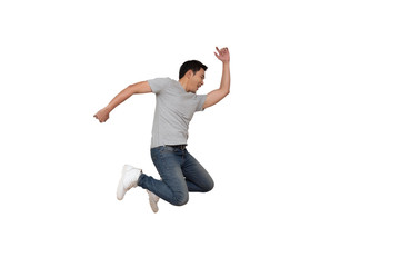 Full length portrait of an excited young Asian man in gray t-shirt jumping while celebrating success or dancing with music isolated over white background