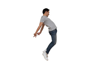 Full length portrait of an excited young Asian man in gray t-shirt jumping while celebrating success or dancing with music isolated over white background