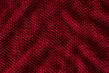 Texture of red knitted sweater closeup, burgundy background