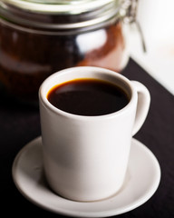 Cup of coffee on wooden background.