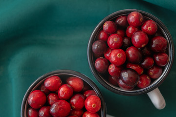 Cranberries. Fresh ripe organic cranberries in a cups directly from above with green background, close up