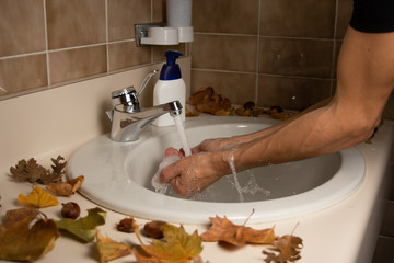 Man collecting water from the bathroom sink with wis hands - obrazy, fototapety, plakaty