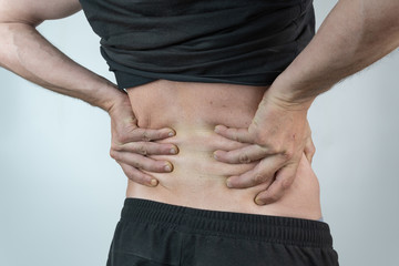 back man dressed in black  with his hands on his kidneys on isolated White background