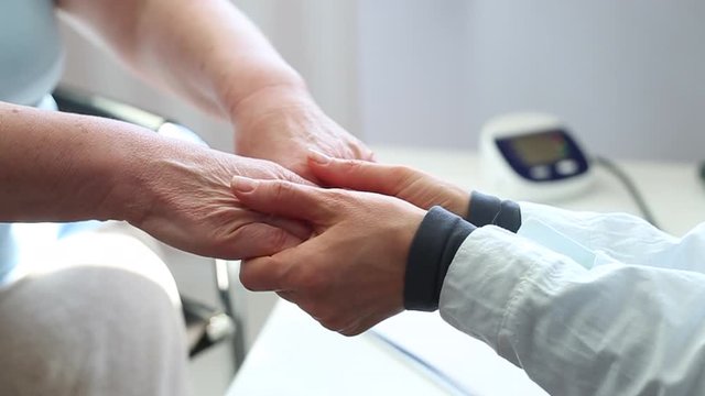 The doctor supports an elderly woman. Hands of a nurse as a sign of help to old people.