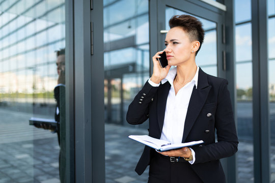 photo of a young ambitious businesswoman on the background of a modern office building