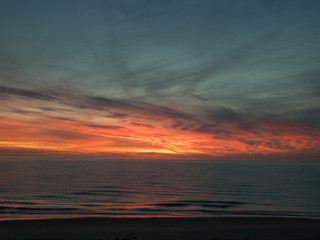 landscape with defocused beautiful dramatic golden sky over the sea, reflection at sunset time, long exposure 