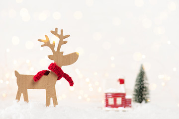 Santa deer in the red scarf in the snow, light festive Christmas composition