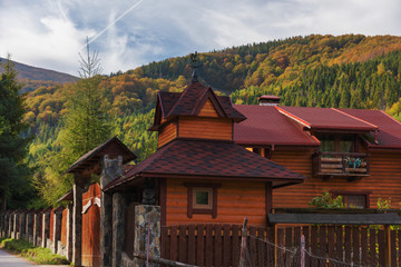 Landscapes on an autumn mountain village, with beautiful houses and golden trees around, located in the Ukrainian Carpathians.