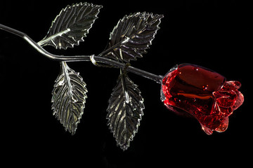 Red and silver colored metallic rose with droplets on black background.