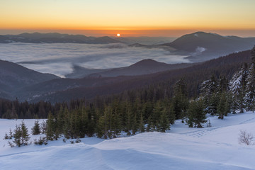 Beautiful winter landscapes from the Ukrainian Carpathian Mountains with traumatic skies and tourists, traveling on ridges