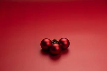 Three red christmas balls and a pinecone