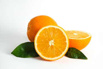 Close up image of juicy organic whole and halved oranges with green leaves & visible core texture, isolated white background, copy space. Macro shot of bright citrus fruit slices. Top view, flat lay.