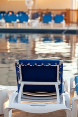 Empty chair at the swimming pool in the morning, vacation and travel concept
