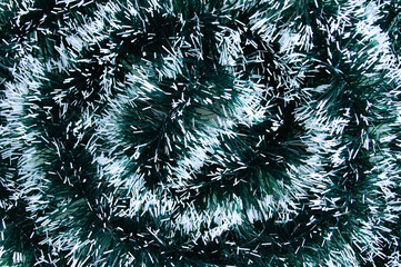 Christmas green tinsel with white edges close-up.