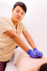 Traditional oriental therapy and beauty treatments. Therapist performing massage on young woman....