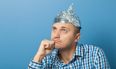 Foil hat on man. Man with a bored face. Protects from reading think