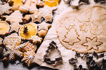 Christmas and New Year celebration traditions. Family home bakery, cooking traditional festive sweets. Gingerbread dough with christmas theme shapes and raw cookies